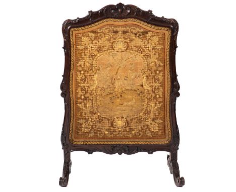 A Victorian carved walnut and Berlin woolwork firescreen, mid 19th Century, the needlework cartouche shaped panel depicting e