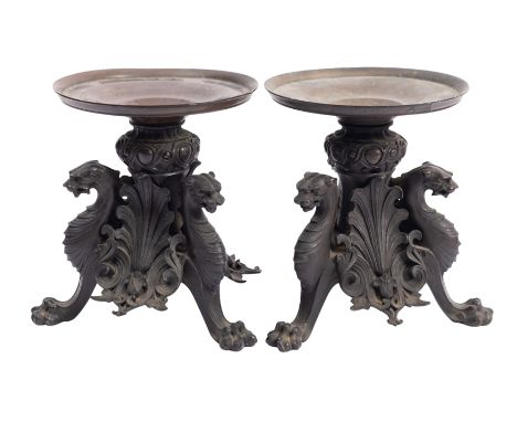A pair of bronze tazzas, circa 1875, the adapted circular tops on tripod supports in the forms of mythical beasts between pal