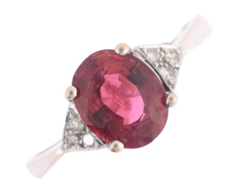 An 18ct white gold ruby and diamond dress ring, claw set with 2.4ct oval mixed-cut ruby, flanked by trio of modern round bril