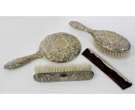 A SILVER BACKED DRESSING TABLE MIRROR together with two brushes and a comb (4)