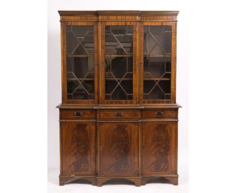 A REPRODUCTION MAHOGANY BREAK FRONT BOOKCASE with three astragal glazed doors above three short drawers and three panelled do