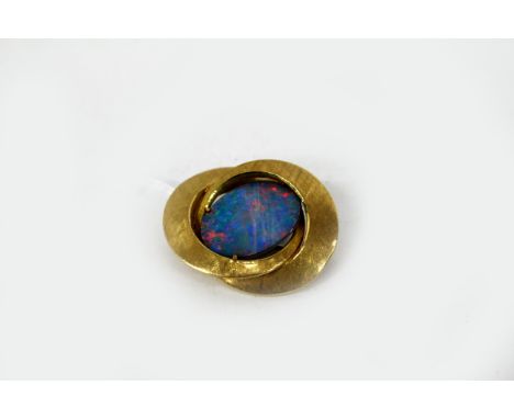 A CONTEMPORARY YELLOW METAL BROOCH of interlinked ring form, centrally decorated with an opal type stone, the pin stamped 750