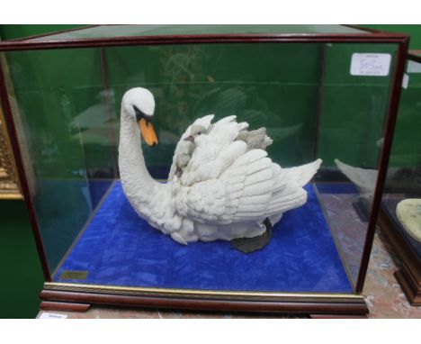A RESIN HAND PAINTED SCULPTURE of a swan and sygnets, approximately 33cm long within a glazed case, the case 44cm long x 36cm