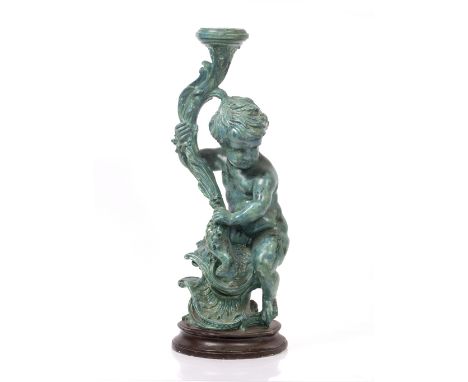 A PAINTED PLASTER LAMP BASE  in the form of a Putti, supporting a torchere on a socle base, 69cm high 
