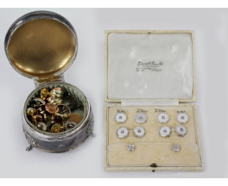 A CIRCULAR SILVER TRINKET BOX with engine turned banded decoration to the top standing on three pad feet and contents therein