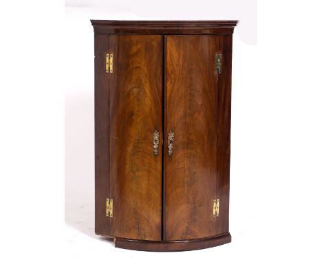 A GEORGE III MAHOGANY BOW FRONTED CORNER CABINET  with brass mounts 69cm wide x 109cm high 