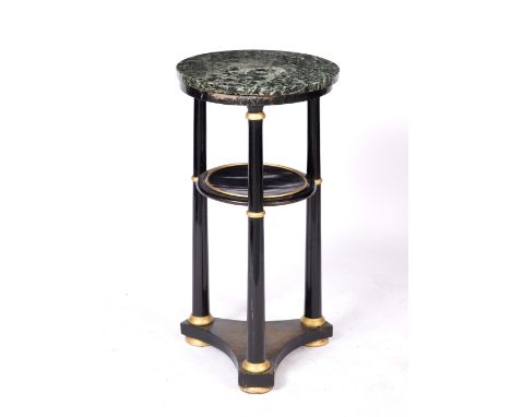 AN EBONISED AND GILDED TWO TIER LAMP TABLE with marble top, turned supports and triform base, 39cm diameter x 76cm high