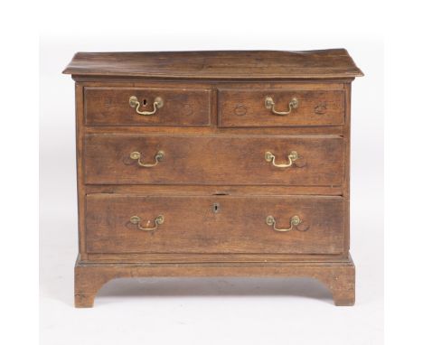 A SMALL 18TH CENTURY OAK CHEST of two short and two long drawers with panelled sides, pegged joints and bracket feet 91cm wid