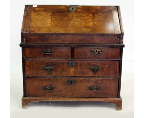 A GEORGIAN BURR WALNUT VENEERED BUREAU the fall front opening to reveal pigeon holes and drawers above two short and two long