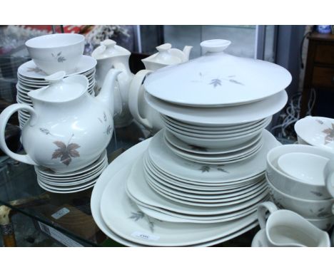 A ROYAL DOULTON TUMBLING LEAVES PATTERN PART DINNER AND TEA SERVICE with meat platters, dinner plates, vegetable tureens, sou
