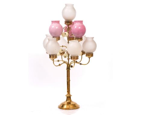 AN OLD BRASS TEN LIGHT CANDELABRUM with glass shades, S shaped arms with turned knops and with turned alabaster finials, 177c