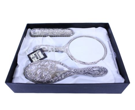 A FOUR PIECE SILVER BACKED DRESSING TABLE SET in original box, consisting of two brushes, a comb and a mirror (4)