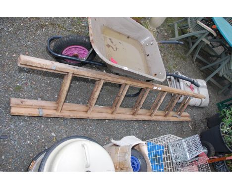 A wooden extending ladder with metal safety stays.