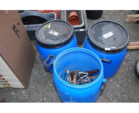 Three small water butts with garden tools, crow bar, wooden mallet, etc.