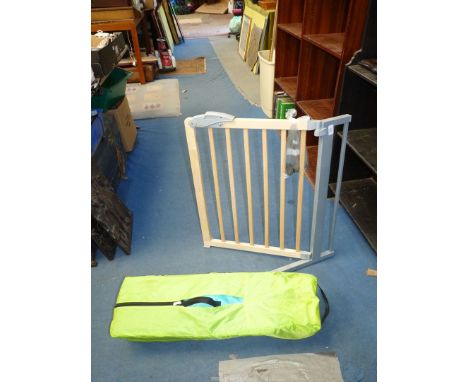 A Hauck travel cot and stair gate.