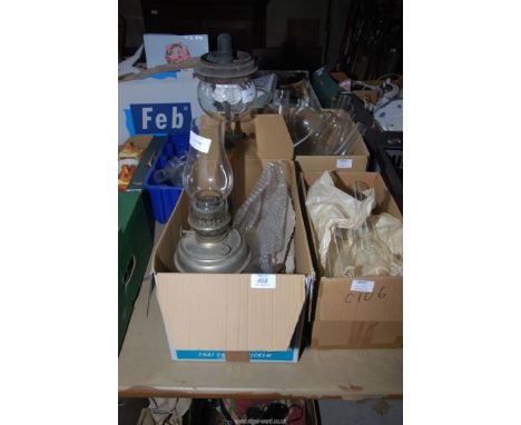 An Aladdin lamp and a box of glass oil lamp chimneys.