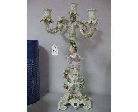 A Continental Dresden Style Ceramic Four Branch Candelabrum, with allover floral encrusting, maiden to support on scroll base