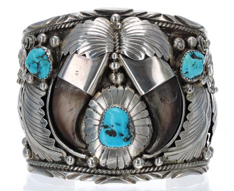 Navajo sterling silver cuff bangle, set with three rough cut turquoise stones and two horn claws surrounded by flowering foli