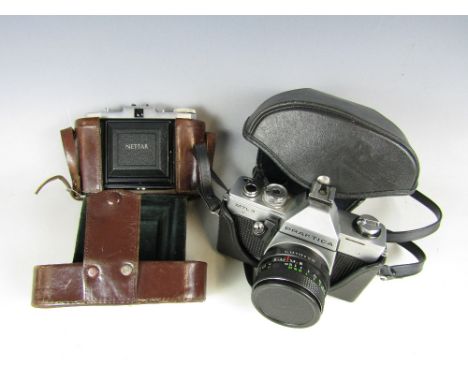 A vintage Zeiss Ikon Nettar camera together with a Praktica MTL3 camera