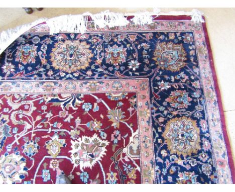 A red patterned 100% wool pile Indian hand knotted carpet