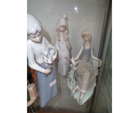 Lladro figure of a recumbent girl with dove, unglazed girl with staff and a similar Spanish figure