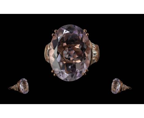 Amethyst and White Topaz Ring, the oval cut amethyst measuring 20mm x 15 and 16cts, an exceptional size and cut, flanked by t