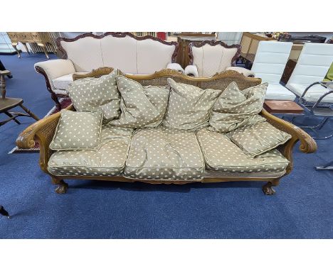 Bergere Settee, carved arm rests and back, raised on lion claw and ball feet.  Drop in cushions.  75'' wide.