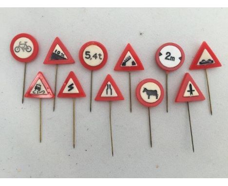 A set of stick pins depicting different road signs.