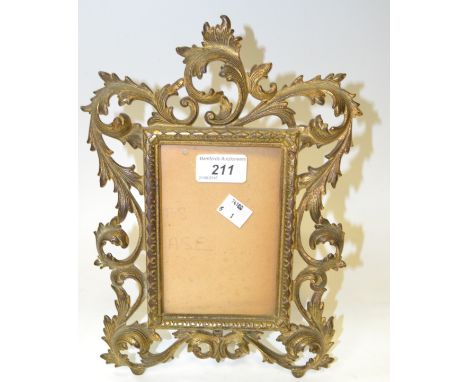 An early 20th century gilt metal easel shaped rectangular photograph frame, cast with pierced leafy scrolls, 28cm x 20cm