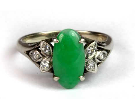 A lovely 14ct white gold ring set with an oval cabochon cut jade and diamond set shoulders (P).