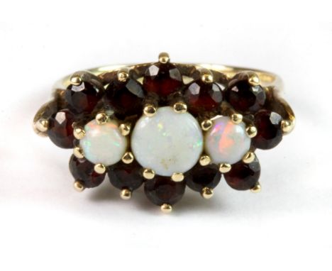 A 9ct yellow gold triple opal and garnet cluster ring (K).