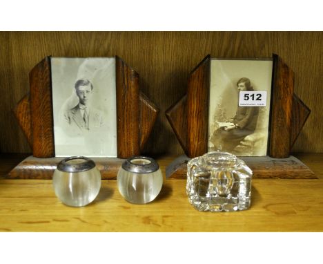 A pair of Art Deco oak photo frames with a pair of glass match strikers and an inkwell.