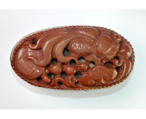 An intricately carved Chinese pebble hardstone scroll weight in the form of a fan tail carp among lotus, L. 9cm.