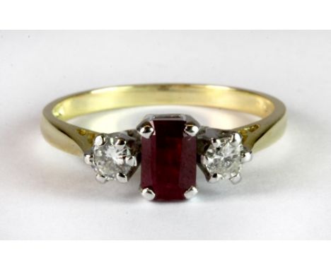 An 18ct yellow and white gold ring set with a centre emerald cut ruby and two brilliant cut diamonds (approx 0.65ct ruby and 