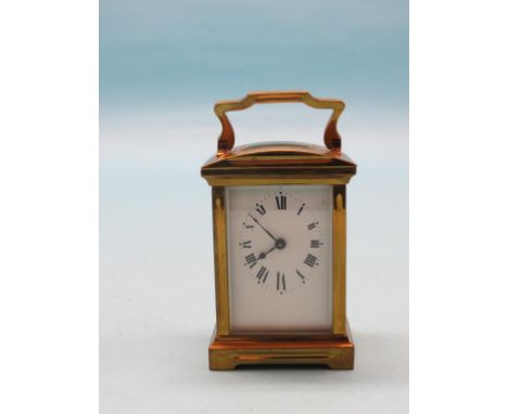An early 20th century French carriage clock, with enamelled dial and oval chapter ring, timepiece movement, in lacquered bras