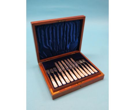 An Edward VII engraved silver dessert set, twelve knives and forks, embossed silver ferrules, mother of pearl handles, G G Rh
