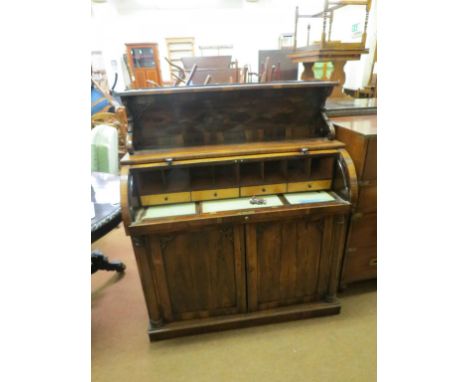 An early Victorian Brazilian rosewood cylinder desk, over-shelf on shaped brackets, cylinder top enclosing an arrangement of 