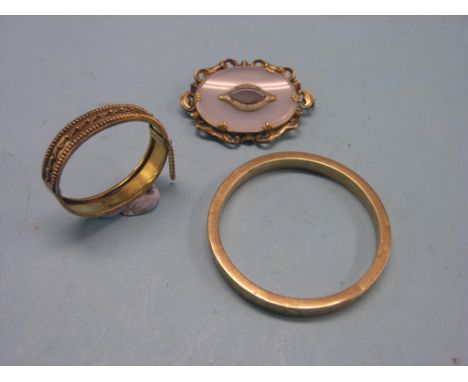A 9ct. engraved gold bangle, 17.2 grams, together with a Victorian gilt-metal bangle and a yellow metal Regard brooch, oval-s
