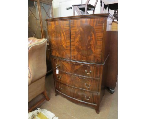 A bow-fronted mahogany linen cupboard, pair of doors enclosing single shelf, three long oak-lined drawers beneath, brass swan