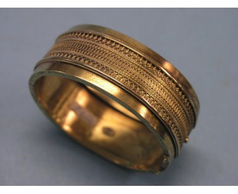 A Victorian 15ct. gold bangle, with filigree border, 33 grams