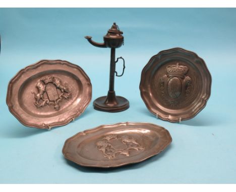 Three 18th century armorial pewter dishes, wave-edge pattern, together with a 19th century pewter oil lamp with integral carr