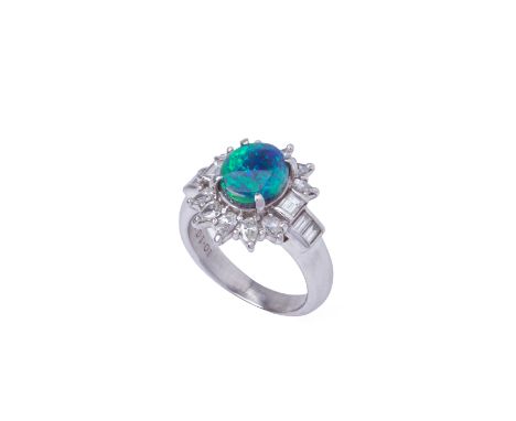 A BLACK OPAL AND DIAMOND CLUSTER RING
Set in platinum, the opal within a surround of baguette and pear cut diamonds 
The opal