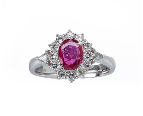 A RUBY AND DIAMOND CLUSTER RING
Set in platinum, the oval cut ruby within a surround of round brilliant and trillion cut diam