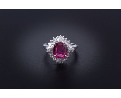 A RUBY AND DIAMOND CLUSTER RING
Set in platinum, the oval cut ruby with a surround of round brilliant cut and tapered baguett
