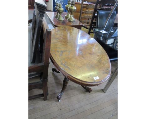 A Victorian walnut veneered centre tableThe oval top raised on four turned supports with swept legs and brass and enamel cast