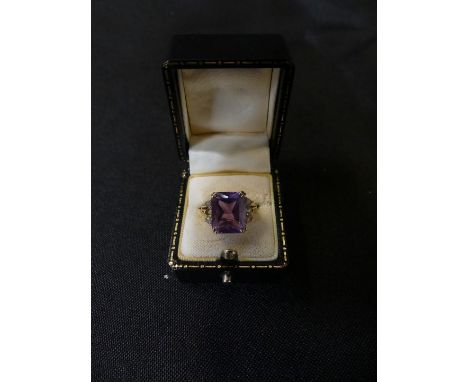 A 9ct gold amethyst and cubic zirconia dress ring The rectangular shaped amethyst with circular shaped cubic zirconia sides, 