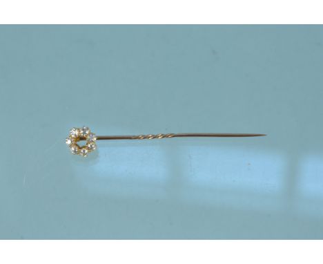 A yellow metal diamond cluster stick pin