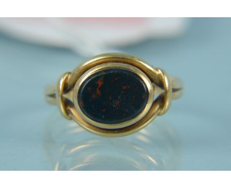 An unmarked yellow metal blood stone set swivel ring, the oval stone with split band design, size K, weight approx 4g