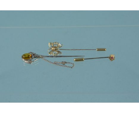 Two 9ct gold stick pins, one of butterfly form and a silver stick pin set with amber