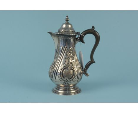 A Victorian silver coffee pot with embossed floral decoration on flared base, engraved with crest, hallmarked Birmingham 1897